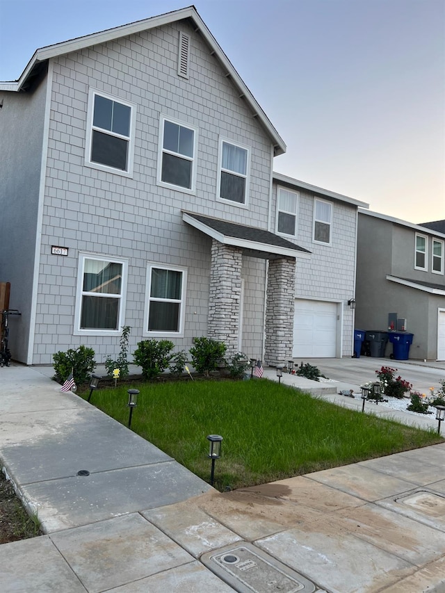 view of front of property featuring a yard and a garage