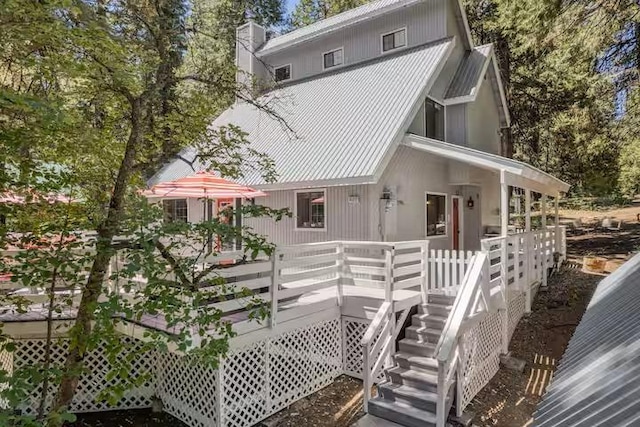 rear view of property featuring a wooden deck