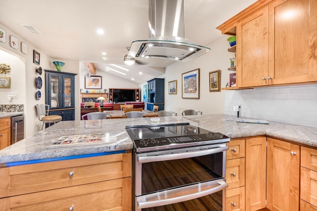 kitchen featuring decorative backsplash, island range hood, light stone counters, and stainless steel electric stove