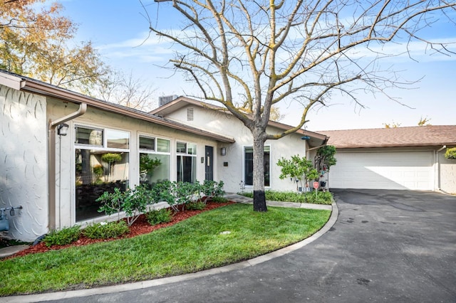 ranch-style house featuring a front yard and a garage