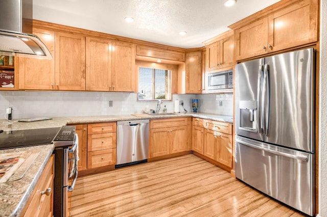 kitchen with sink, stainless steel appliances, light hardwood / wood-style floors, and range hood