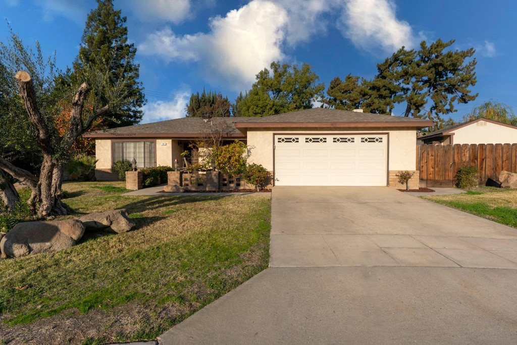 single story home featuring a front yard and a garage