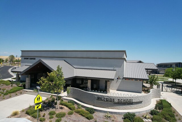 view of front facade with metal roof, a standing seam roof, and stone siding