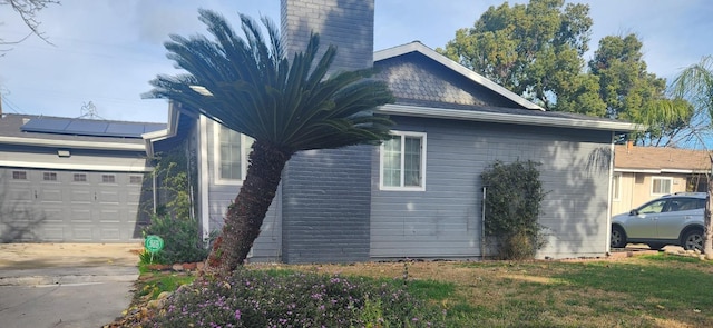 view of side of home featuring solar panels and a yard