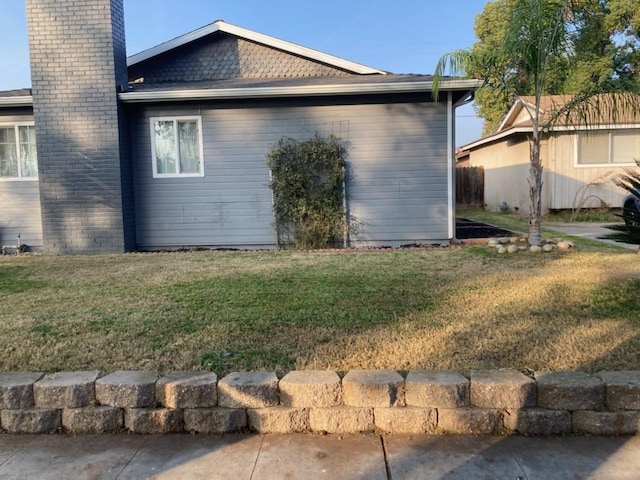 view of side of home with a yard