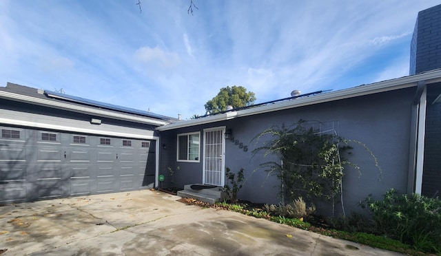 view of home's exterior with solar panels and a garage