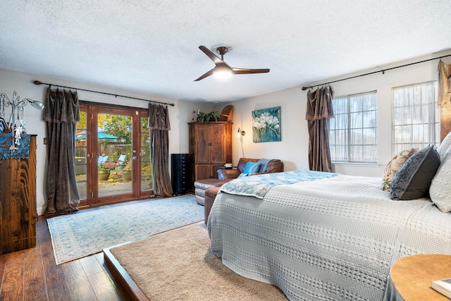 bedroom featuring access to outside, ceiling fan, hardwood / wood-style floors, and a textured ceiling