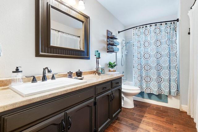 full bathroom with shower / tub combo with curtain, vanity, wood-type flooring, and toilet