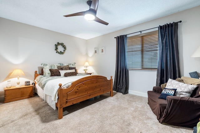 carpeted bedroom with ceiling fan and a textured ceiling