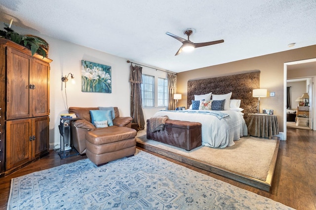 bedroom featuring ceiling fan, dark hardwood / wood-style flooring, and a textured ceiling