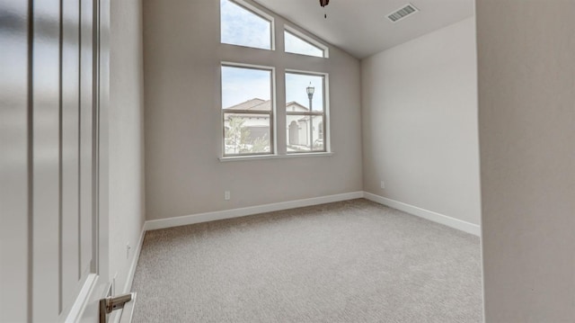 carpeted empty room with ceiling fan and lofted ceiling