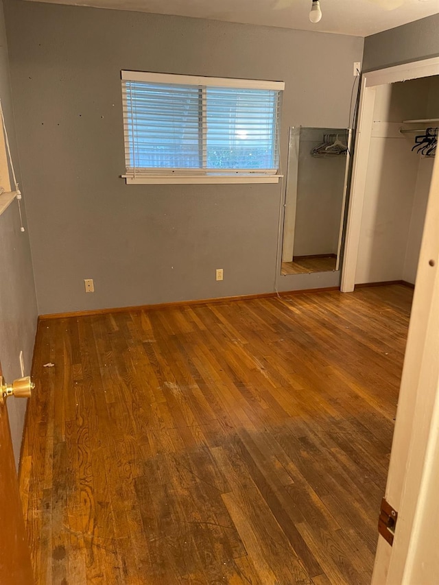 unfurnished bedroom featuring hardwood / wood-style floors and a closet