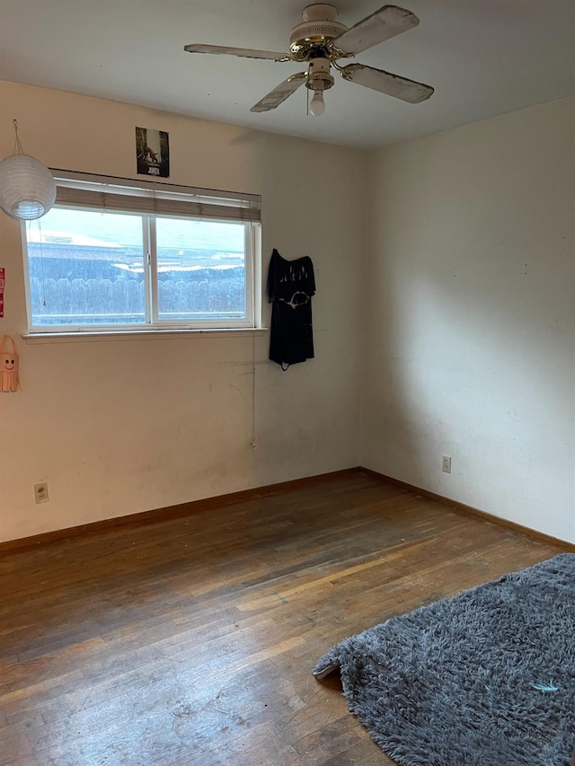 spare room with dark hardwood / wood-style flooring, a wealth of natural light, and ceiling fan