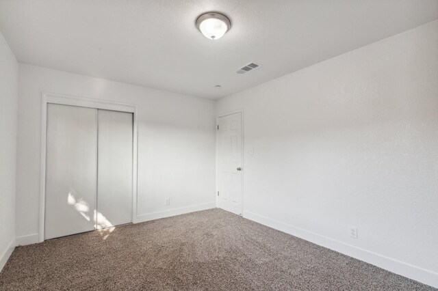 unfurnished bedroom featuring carpet flooring and a closet