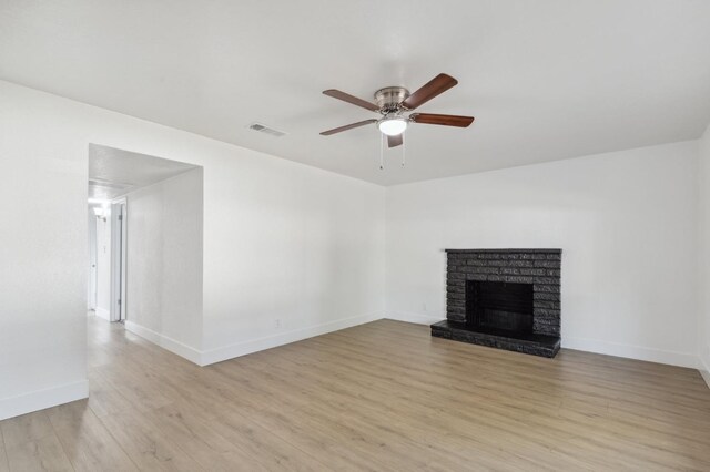 unfurnished living room featuring a fireplace, ceiling fan, and light hardwood / wood-style flooring