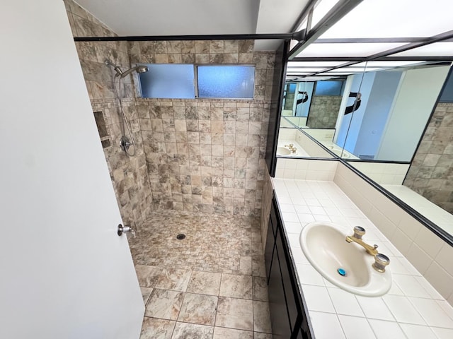 bathroom featuring tiled shower and vanity