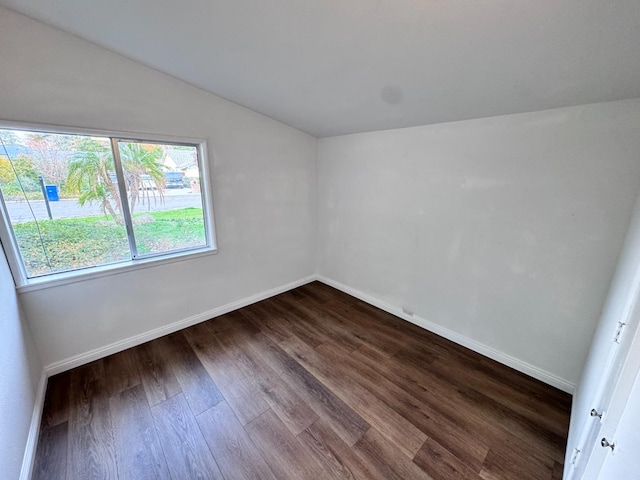 empty room featuring dark hardwood / wood-style flooring and lofted ceiling