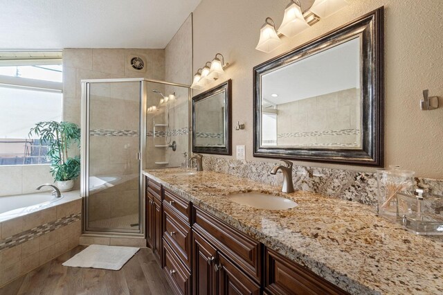5870 E Midwick Ln, Fresno, CA 93727 - bathroom with double vanity, a bath, a stall shower, a textured wall, and wood finished floors