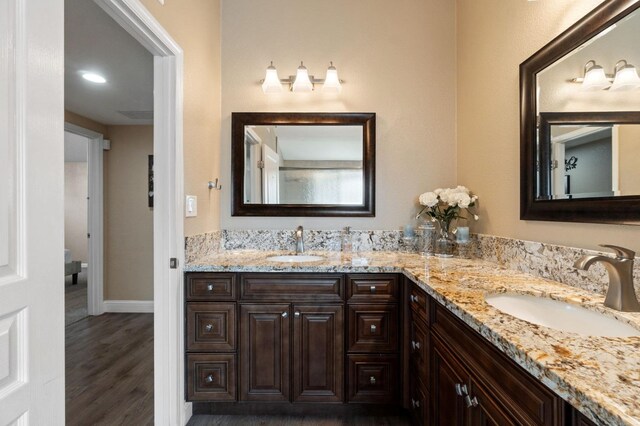 5870 E Midwick Ln, Fresno, CA 93727 - full bathroom with double vanity, wood finished floors, baseboards, and toilet