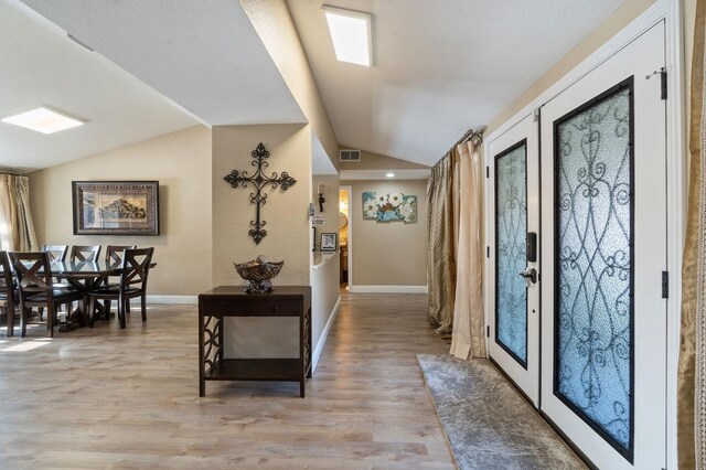 5870 E Midwick Ln, Fresno, CA 93727 - foyer entrance featuring lofted ceiling, light wood-style flooring, and baseboards