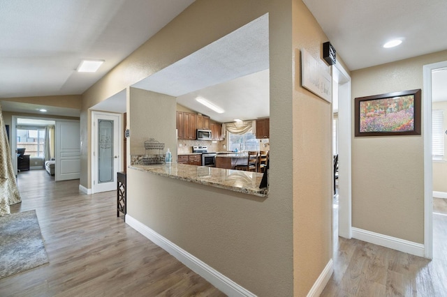5870 E Midwick Ln, Fresno, CA 93727 - kitchen with appliances with stainless steel finishes, brown cabinetry, light wood-style flooring, vaulted ceiling, and a textured wall
