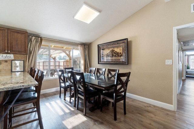 5870 E Midwick Ln, Fresno, CA 93727 - dining room with lofted ceiling, light wood-type flooring, plenty of natural light, and baseboards