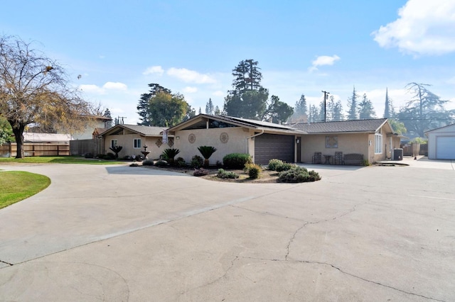 5870 E Midwick Ln, Fresno, CA 93727 - view of front of home with curved driveway, stucco siding, a garage, and roof mounted solar panels