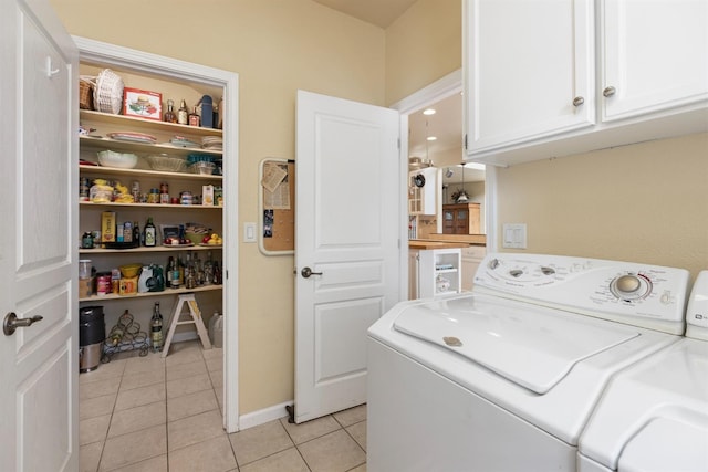 laundry room with cabinets, washer and clothes dryer, and light tile patterned flooring