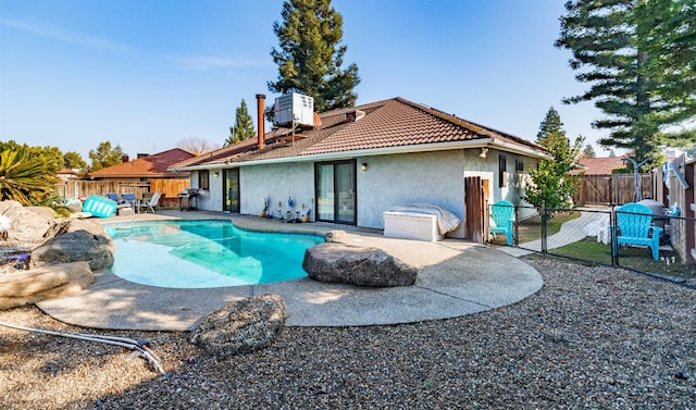 view of pool with cooling unit and a patio area