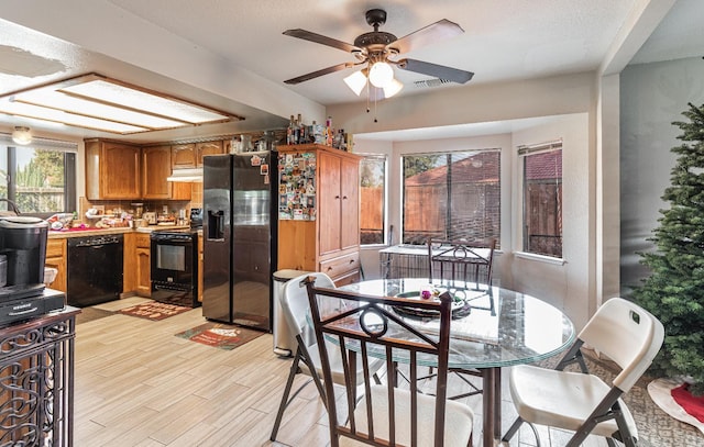 kitchen featuring ceiling fan, a textured ceiling, light wood-type flooring, and black appliances