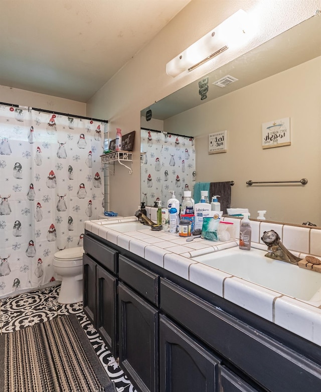 bathroom with vanity, tile patterned floors, and toilet