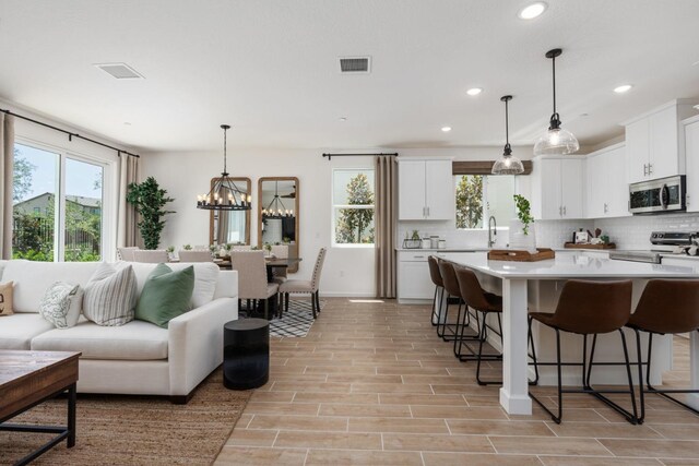 interior space featuring light wood-type flooring, sink, and a notable chandelier