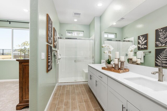 bathroom with vanity and a shower with door