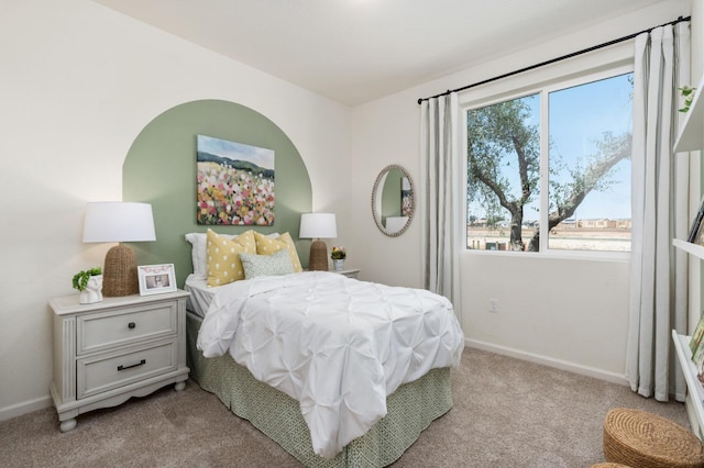 bedroom with baseboards and light carpet