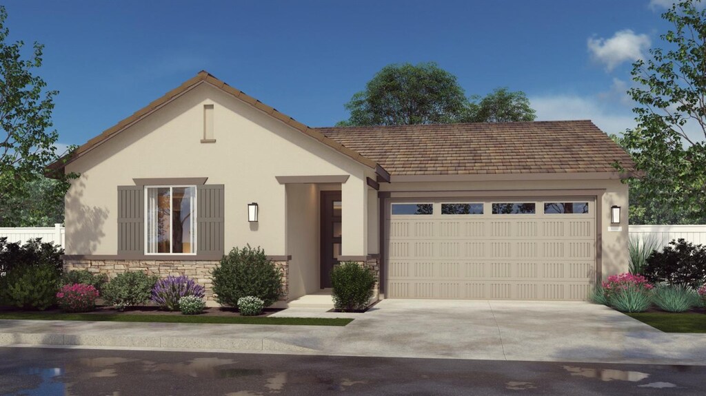 view of front of property featuring stone siding, an attached garage, driveway, and stucco siding