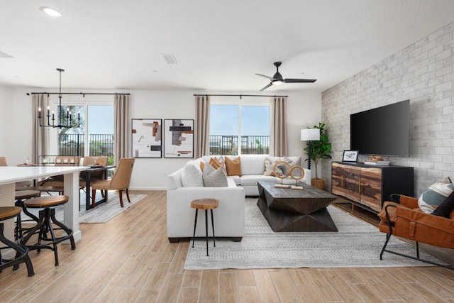 living room with plenty of natural light and ceiling fan with notable chandelier