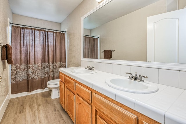 bathroom featuring a shower with curtain, toilet, vanity, and hardwood / wood-style flooring