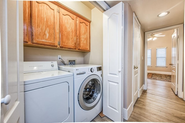 clothes washing area featuring washing machine and dryer, ceiling fan, cabinets, and light wood-type flooring