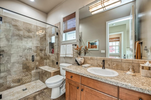 bathroom with tile patterned floors, vanity, toilet, and a shower with door