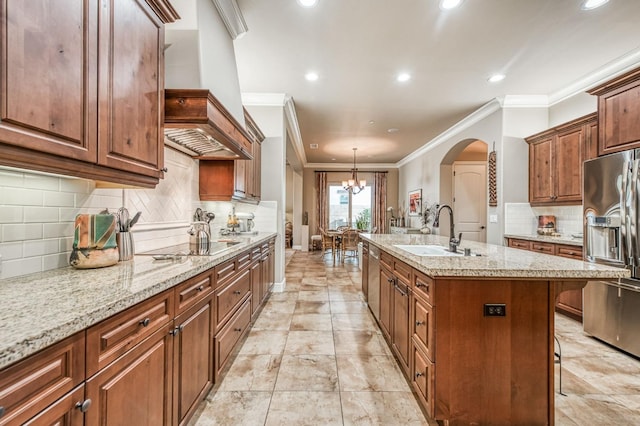 kitchen featuring stainless steel appliances, an inviting chandelier, a breakfast bar area, a kitchen island with sink, and custom exhaust hood