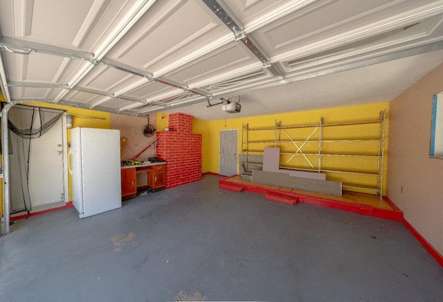 garage featuring white fridge and a garage door opener