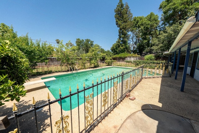 view of pool featuring a diving board and a patio area