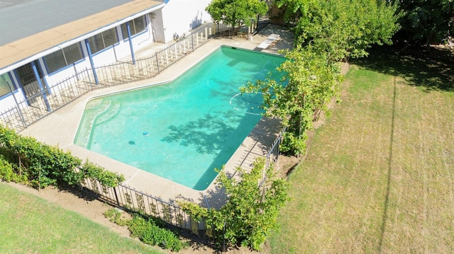 view of swimming pool with a yard