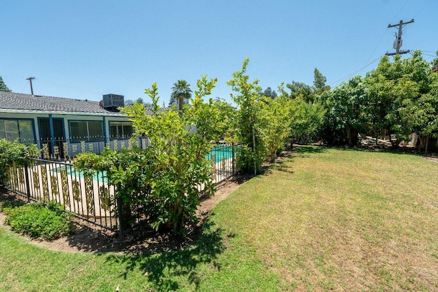 view of yard featuring a fenced in pool and central AC unit