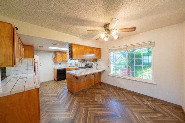 kitchen featuring kitchen peninsula, dark parquet flooring, tasteful backsplash, ceiling fan, and stainless steel range oven