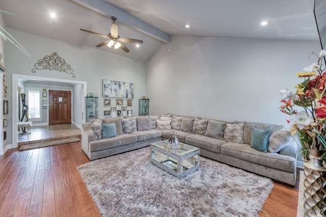 living room with beamed ceiling, ceiling fan, light hardwood / wood-style floors, and high vaulted ceiling