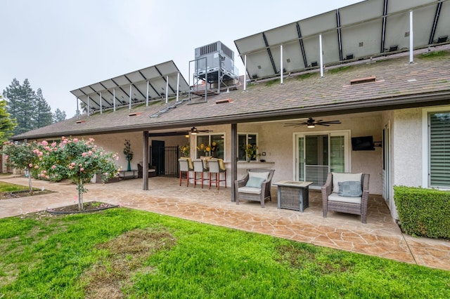 rear view of property featuring ceiling fan, a patio area, and a bar