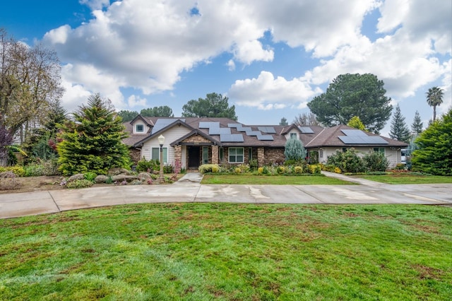 view of front of property with a front lawn and solar panels