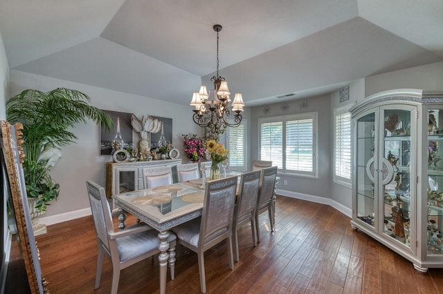 dining area featuring dark hardwood / wood-style flooring, lofted ceiling, and an inviting chandelier