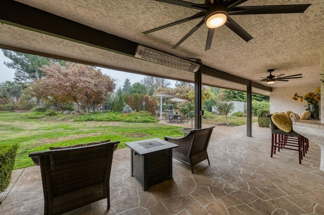 view of patio / terrace with ceiling fan and an outdoor bar